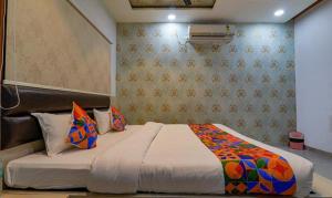 een slaapkamer met een groot bed met kleurrijke kussens bij FabHotel Super 3 Premium in Varanasi