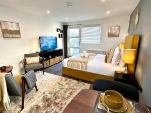 - une chambre avec un lit, une télévision et un canapé dans l'établissement A Cozy Hideaway with Balcony - Close to Beach, à Bournemouth