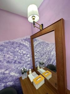 ein Badezimmer mit einem Spiegel und einem Tisch mit einer Lampe in der Unterkunft Kenting Sea Cloudless Day Home in Kenting