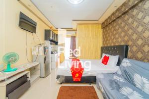 Kleines Zimmer mit einem Bett und einem TV in der Unterkunft RedLiving Apartemen Cibubur Village - Lily's Room Tower C in Depok