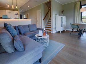ein Wohnzimmer mit einem Sofa und einem Tisch in der Unterkunft Reetland am Meer - Premium Reetdachvilla mit 3 Schlafzimmern, Sauna und Kamin F27 in Dranske