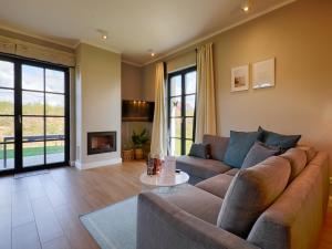 ein Wohnzimmer mit einem Sofa und einem Tisch in der Unterkunft Reetland am Meer - Premium Reetdachvilla mit 3 Schlafzimmern, Sauna und Kamin F27 in Dranske