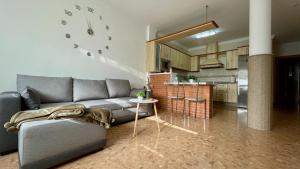 a living room with a couch and a kitchen at Palacio de Ferias apartamento in Málaga