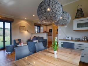 eine Küche und ein Wohnzimmer mit Tisch und Stühlen in der Unterkunft Reetland am Meer - Premium Reetdachvilla mit 3 Schlafzimmern, Sauna, Kamin und Massagesessel F05 in Dranske