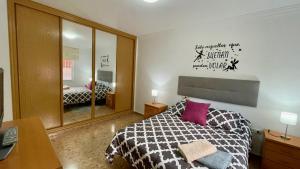 Un dormitorio con una cama en blanco y negro y un espejo en Palacio de Ferias apartamento, en Málaga