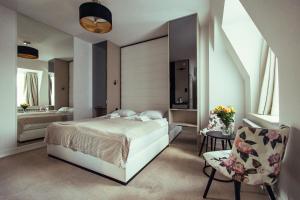 una camera con letto e sedia e un bagno di Hotel - Apartamenty Heban a Toruń