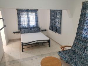 um pequeno quarto com uma cama e duas janelas em TRANQUIL RESORT HOTEL em Brusubi