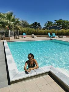 a woman sitting in a swimming pool at Camping Hameau Des Cannisses in Gruissan