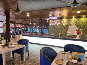 un ristorante con tavoli e sedie e un bar di Paradise Village Beach Resort a Calangute