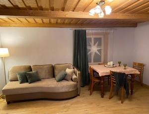 uma sala de estar com um sofá e uma mesa em Dzirnavkalns em Cesvaine