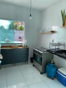 a kitchen with a stove and a sink in it at Casa Arembepe in Camaçari