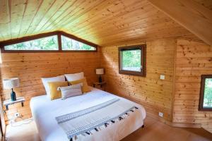 um quarto num chalé de madeira com uma cama grande em Le Chalet - Les Lodges de Praly em Les Ollières-sur-Eyrieux