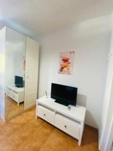 een woonkamer met een tv en een spiegel bij VV Faro in Puerto de Mogán