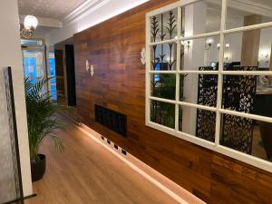 eine Lobby mit einer Holzwand und Fenstern in der Unterkunft Hotel du Louvre in Cherbourg en Cotentin