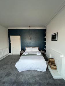 Complete Osborne House by Prescott Apartments في بريستول: غرفة نوم بسرير كبير بجدار ازرق