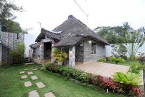 a small house with a grass roof at Deekay Villa Yelagiri By Lexstays in Yelagiri