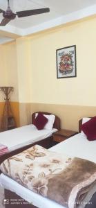 Habitación con 2 camas y una foto en la pared. en The Lumbini Village Lodge, en Rummindei