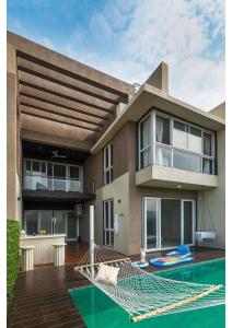 una casa con hamaca frente a una casa en Grey villa pure veg 4BHK, en Lonavala