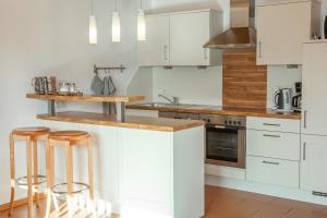 a kitchen with white cabinets and bar stools at Haus Geier in Rieden