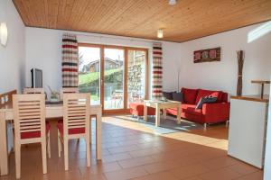 sala de estar con mesa y sofá rojo en Haus Geier, en Rieden