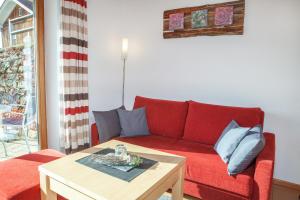 a living room with a red couch and a coffee table at Haus Geier in Rieden