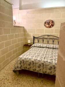 オーリアにあるLa Corte del Reのレンガの壁にベッド1台が備わるベッドルーム1室