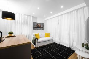 sala de estar con sofá blanco y almohadas amarillas en Apartmaji Spalina, Ivančna Gorica 