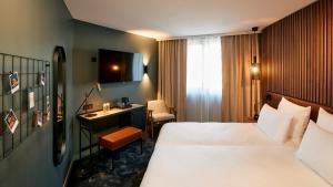 a hotel room with a bed and a desk at Le Bellune Paris in Paris