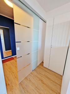 um armário num quarto com armários brancos e pisos de madeira em Stadtgebiet EIC-018 em Heiligenhafen