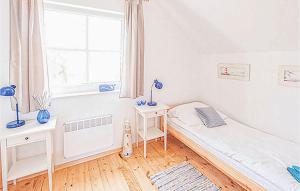 a bedroom with a bed and a desk and a window at 2 Bedroom Stunning Home In Ustka in Ustka