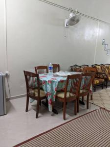 a dining room table with chairs and a bottle of water on it at Homestay Sejati in Kuala Berang