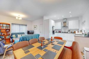 a kitchen and a dining room with a table and chairs at Beautiful 4-bedroom house in Victoria Park in London