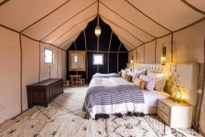 a bedroom with a large bed in a tent at Mourad desert camp in Merzouga