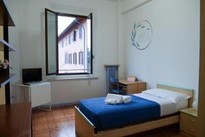 Un dormitorio con una cama azul y una ventana en Il Villaggio di ABITABO, en Bolonia