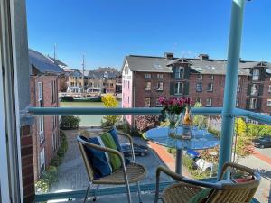 een balkon met een tafel en stoelen bij Hafenblick-City Apartment Husum in Husum