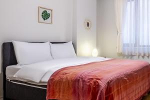 - une chambre avec un lit et une couverture rouge dans l'établissement Comfy, à Istanbul