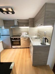 uma cozinha com electrodomésticos em aço inoxidável e pisos em madeira em Stylish apartment, very good located! em Sófia