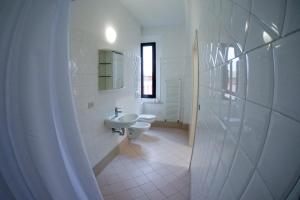 Baño blanco con lavabo y aseo en Il Villaggio di ABITABO, en Bolonia