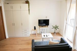 uma sala de estar com um sofá e uma televisão em Stylish apartment, very good located! em Sófia