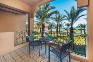 een balkon met een tafel en stoelen en palmbomen bij Iberostar Averroes in Hammamet