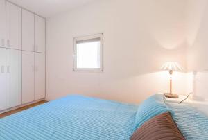 - une chambre avec un grand lit bleu et une fenêtre dans l'établissement close to the hilton with balcony, à Tel Aviv