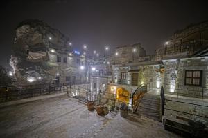 a building at night with snow on the ground at Risus Cave Suites in Goreme