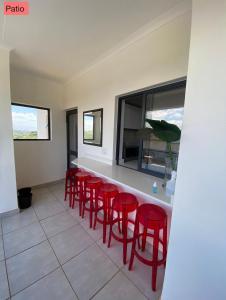 un bar con taburetes rojos en una habitación en BALLITO HILLS , 2 bedroom apartment, en Ballito