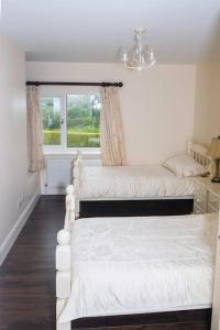 a bedroom with two beds and a window at Island Winds Along The Atlantic Way in Killala