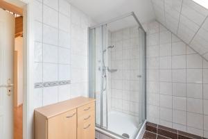 ein Badezimmer mit einer Dusche und einem Holzschrank in der Unterkunft Haus Liberty 2 in Büsum
