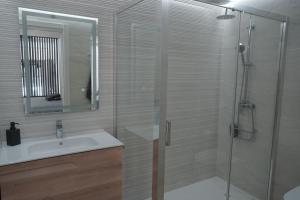 y baño con lavabo y ducha acristalada. en Apartamento Turistico Hermanos Infantes, en Estepona