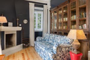 a living room with a blue couch and a fireplace at Casa do Presidente in Lisbon