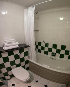 a bathroom with a tub and a toilet and a sink at Riverside Lodge Hotel in Irvine