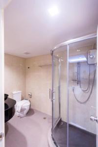 uma casa de banho com um WC e uma cabina de duche em vidro. em Royal Asia Hotel Pratunam em Bangkok