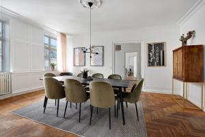 Sanders Square - Spacious Six-Bedroom Apartment Near Amalienborg في كوبنهاغن: غرفة طعام مع طاولة وكراسي